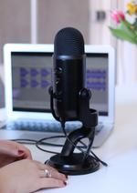 Two women speaking together in front of a microphone.