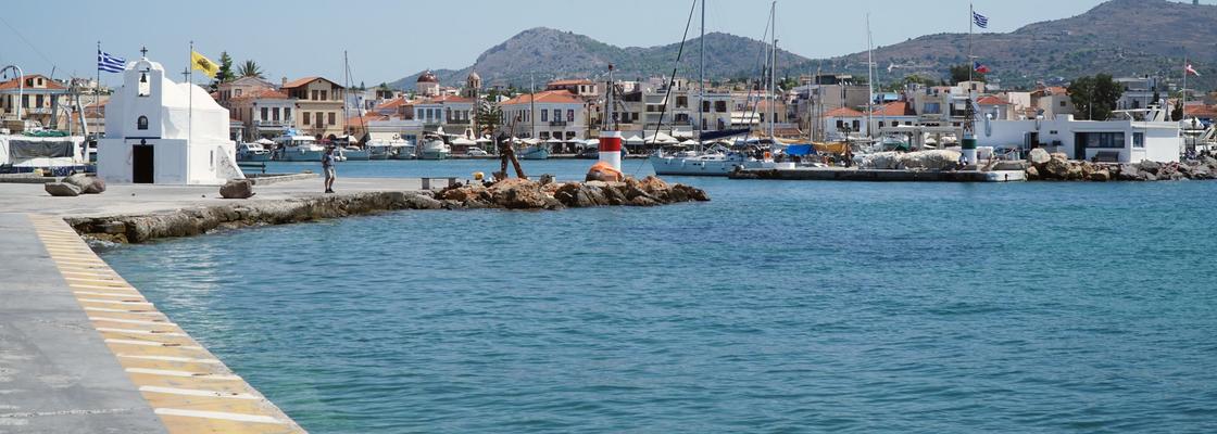 The harbour in Aegina island (Greece) with green mountains in the background.