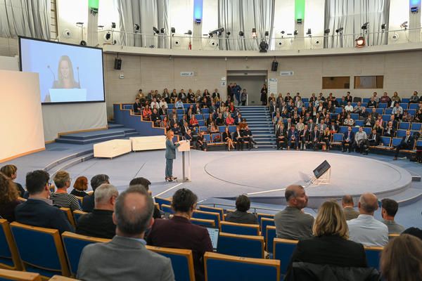 Auditorium of audience members watch a speaker on stage during the opening plenary of Urban Mobility Days 2022.