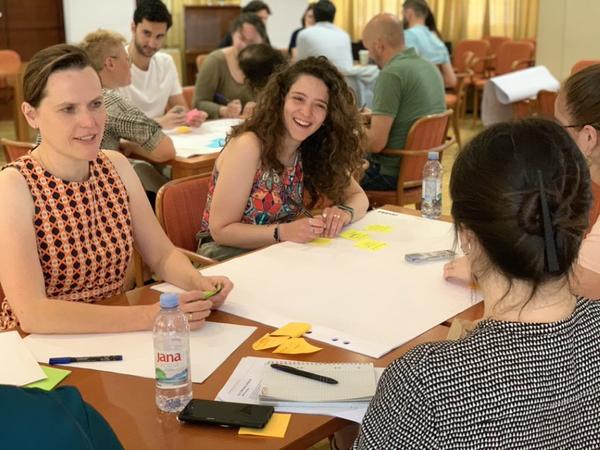 Smiling people work together at a table at the CIVINET Forum
