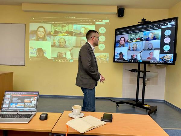 Image of a lecturer in front of a high-tech hybrid learning set-up
