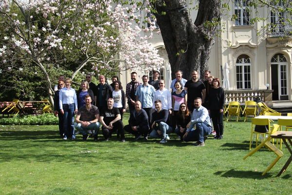 Study trip participants pose for a photo in a green space on a sunny day