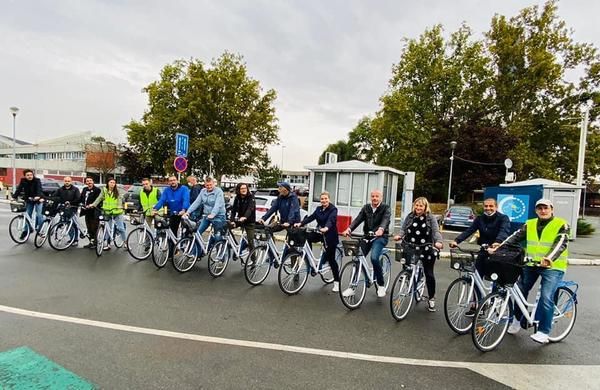 Group of 15+ people in a line on their bicycles, facing the camera