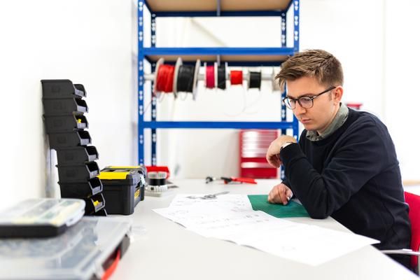 Man looks at plans at a desk