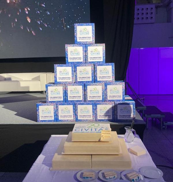 Celebratory CIVITAS cubes stacked in the background, and a three-tiered "20 Years of CIVITAS" cake in the foreground.
