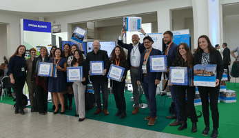 Group in front of the CIVITAS stand at UMD holder up cubes that celebrate achievements from the past 20 years of CIVITAS.