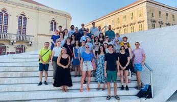 Participants in the summer school standing on steps in a public space in the city