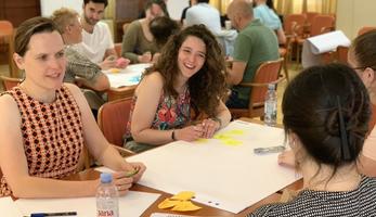 Smiling people work together at a table at the CIVINET Forum
