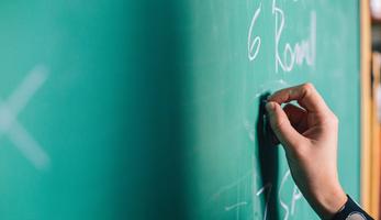 Hand on blackboard writing