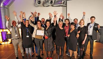 Representatives from the City of Aachen throwing their arms in the air in celebration of their award win.