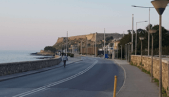 Cyclist biking along the water in Crete
