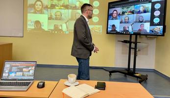 Image of a lecturer in front of a high-tech hybrid learning set-up
