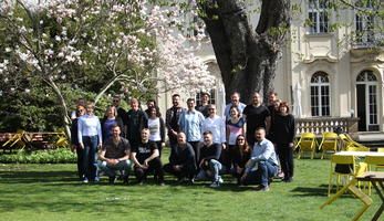 Study trip participants pose for a photo in a green space on a sunny day