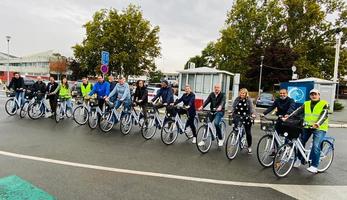 Group of 15+ people in a line on their bicycles, facing the camera