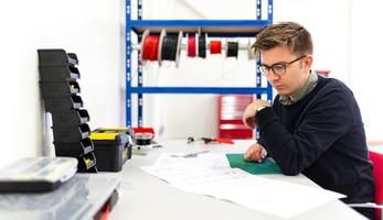 Man looks at plans at a desk
