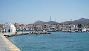 The harbour in Aegina island (Greece) with green mountains in the background.